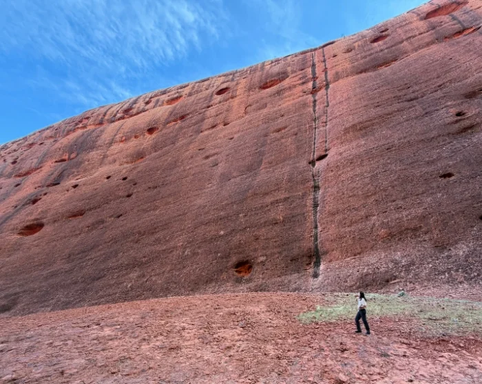 Walpa Gorge Kata Tjutalla Australiassa, nainen valtavien punaisten kallioseinämien edustalla