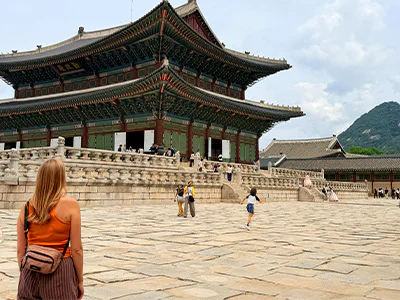 Nainen seisoo ja katselee Gyeongbokgungin palatsia Soulissa