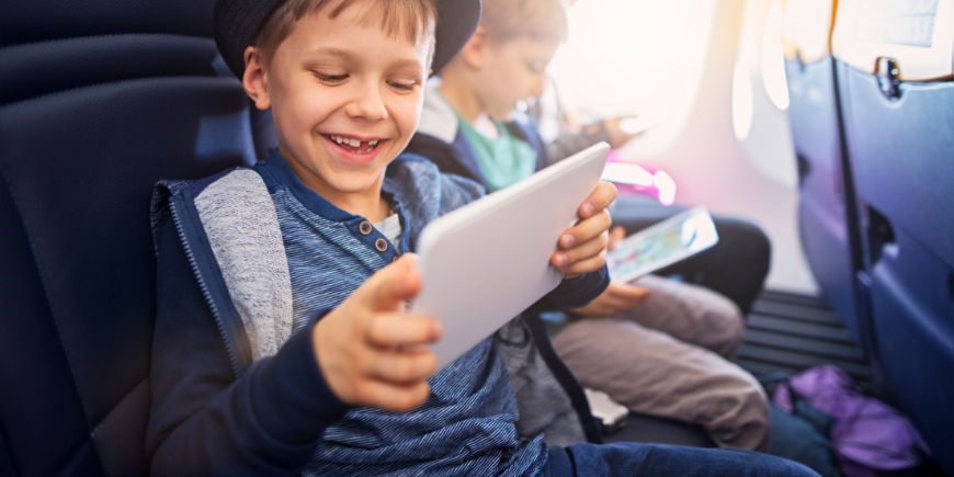 Lapsi leikkii iPadin kanssa lennolla