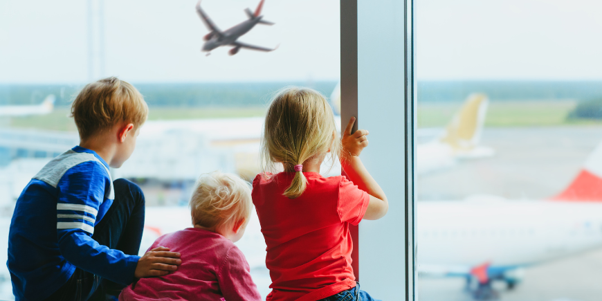Kolme lasta odottaa lentokentällä