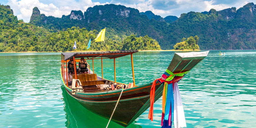 Perinteinen pitkähäntävene ja kaunis maisema Ratchapraphan padolla Khao Sokin kansallispuistossa Surat Thanin maakunnassa Thaimaassa.
