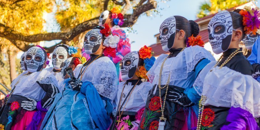 Naisia värikkäissä puvuissa ja koristeltuja kalloja kuolleiden päivänä Meksikossa
