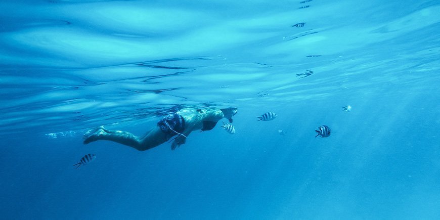 Nainen snorklaamassa veden alla Sansibarilla