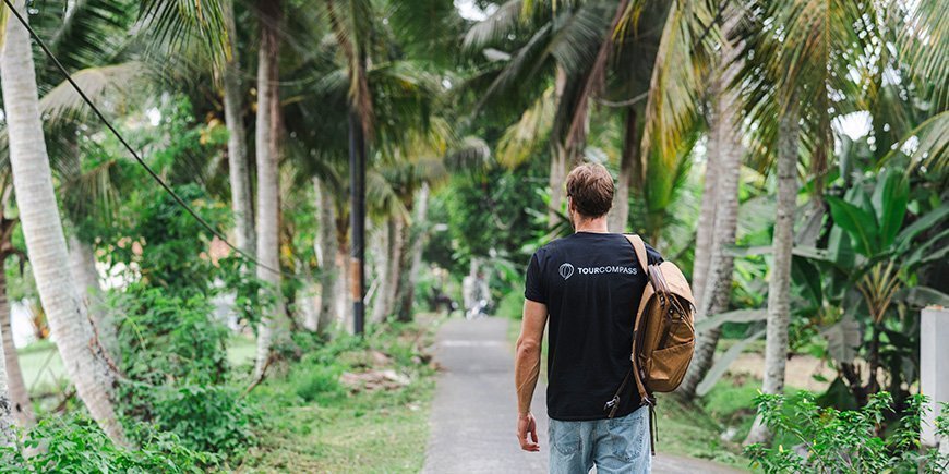 Mies kävelee palmujen alla Balilla, Indonesiassa.
