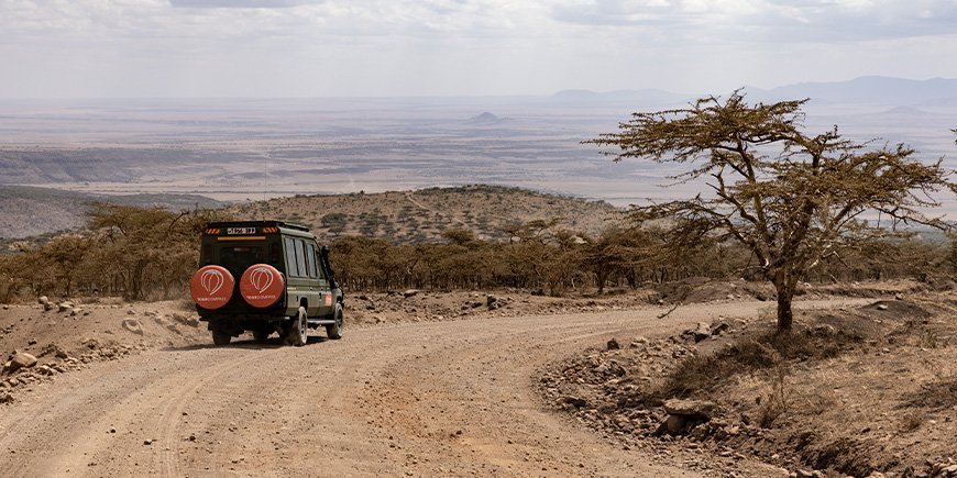 TourCompass-logolla varustettu nelivetoauto lähtee safarille Tansaniaan