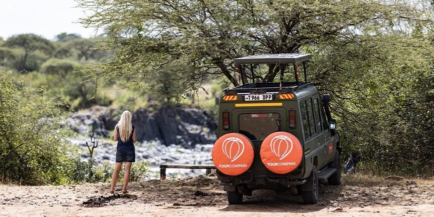 Nainen ja TourCompassin jeeppi Tansaniassa
