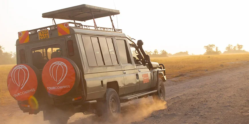 Jeep, jossa on TourCompassin logo, ajaa savannilla Keniassa