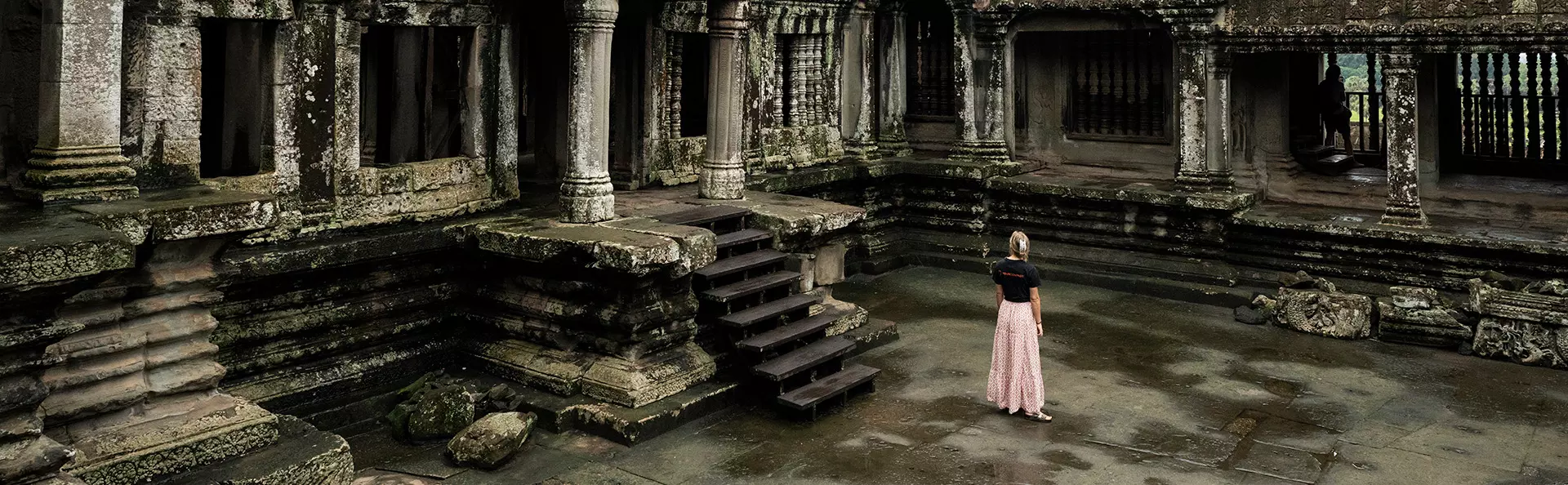 Nainen TourCompass-paita päällä tutkii Angkorin raunioita